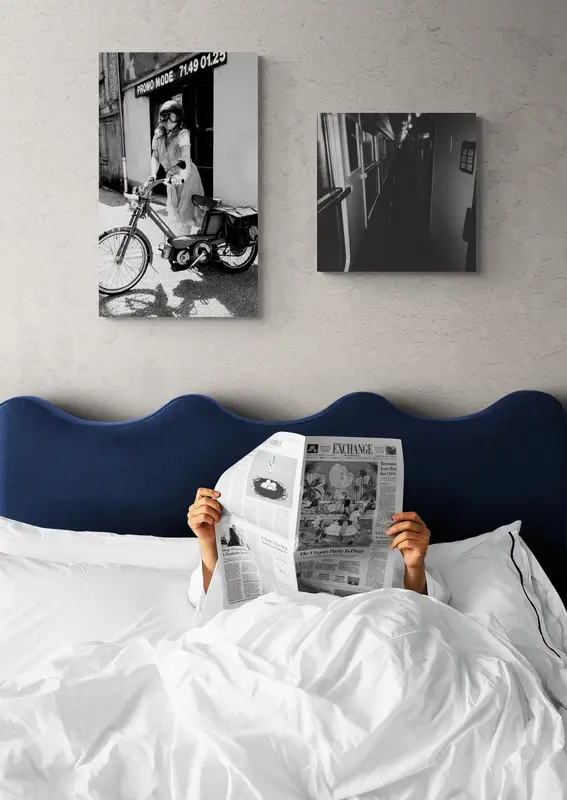 man reading newspaper in bed